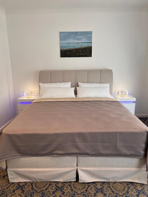 Luxuriöses Doppelbett im stilvollen Zimmer Rosengarten des Art Hotel House One Baden-Baden – mit eleganter Bettbeleuchtung und modernem Design